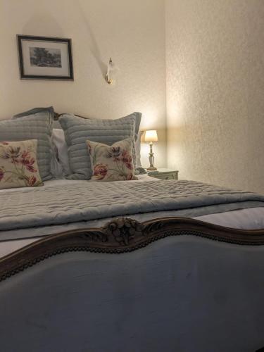 a bedroom with a large bed with pillows at Lydgate House Hotel in Postbridge