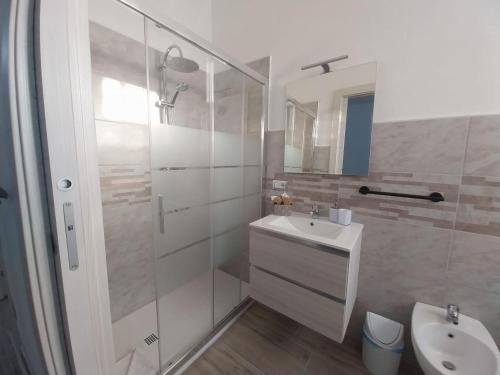 a white bathroom with a sink and a shower at S'Istella Affittacamere in Tinnura