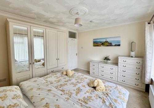 a bedroom with a large bed and white cabinets at Trehwfa in Holyhead