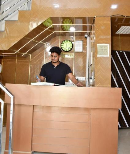 a man standing behind a counter in a kitchen at Hotel president jodhpur in Jodhpur