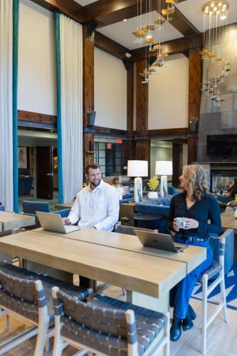 a man and woman sitting at a table with laptops at Martis Valley Lodge, Tapestry Collection by Hilton in Truckee