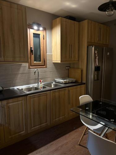a kitchen with wooden cabinets and a sink and a refrigerator at 'Olea Luxury House in Elia Laconias