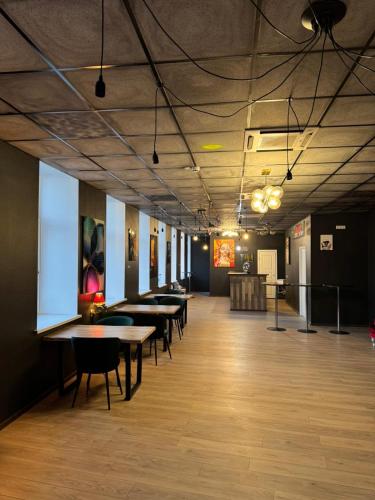 a room with tables and chairs in a building at Hedgehogs backpackers hostel in Rīga