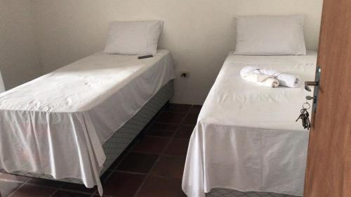 twee bedden naast elkaar in een kamer bij Santa Ana da Ribeira in SantʼAnna do Ipanema