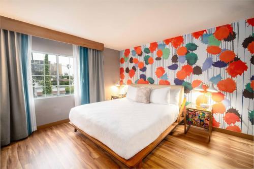 a bedroom with a bed and a floral wall at The Kinney - Venice Beach in Los Angeles