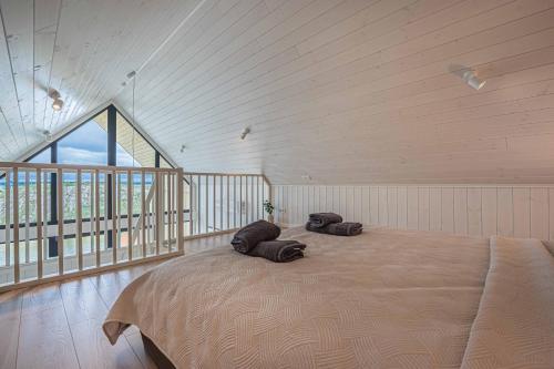 a bedroom with a large bed with two pillows on it at Pondside Cabin - Sauna - Terrace - Near Wake Park in Kiauleikiai