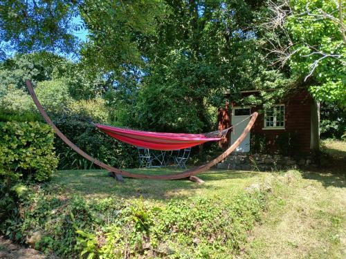 a hammock in the yard of a house at An Koad - Cabane au bord de l'eau in Plougastel-Daoulas