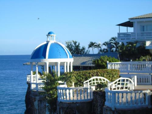 a white and blue gazebo next to the water at Piergiorgio Palace Hotel in Sosúa