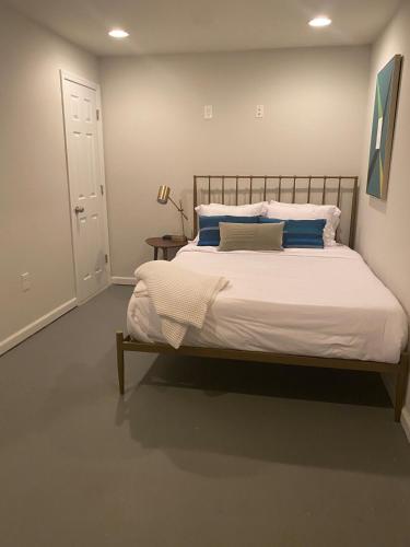 une chambre avec un grand lit avec des oreillers bleus dans l'établissement Cozy 2BR suite w Sauna, à Leesburg
