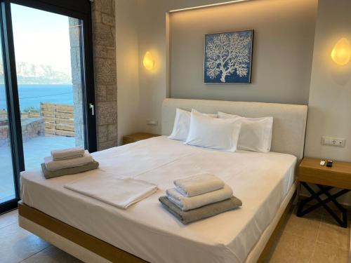 a bedroom with a bed with towels on it at Stone Crafted Luxury Villas in Nikiana