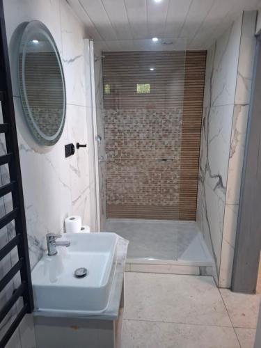 a bathroom with a sink and a shower at Domek na pensjonatowej 8 in Augustów
