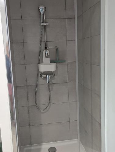 une douche avec pommeau de douche et un lavabo dans l'établissement Studio des Pins, à Hourtin