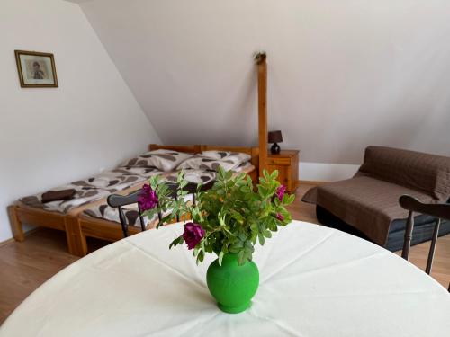 a room with a table with a vase with flowers on it at Domek u Pawła in Piwniczna