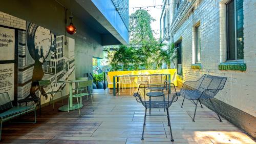 un patio avec des chaises et des tables dans un bâtiment dans l'établissement The Hollywood Franklin Hotel near Universal Studios, à Los Angeles