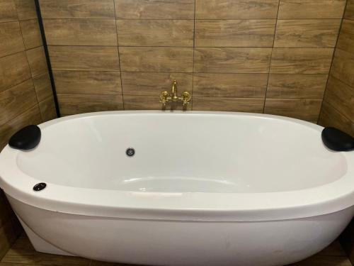 La salle de bains est pourvue d'une baignoire blanche et d'un mur. dans l'établissement Monte Hermon hospedagem, à Bom Jardim da Serra