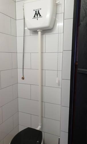 a white tiled bathroom with a toilet and a sink at Le Making Of Chambres d'Hôtes insolites et Familiales in Thairé
