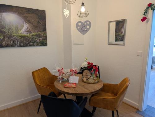 a table in a room with chairs and a table with wine glasses at Villa Baumhaus Apartments in Hamm