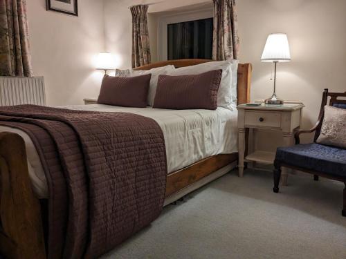 a bedroom with a large bed and a chair at Lydgate House Hotel in Postbridge