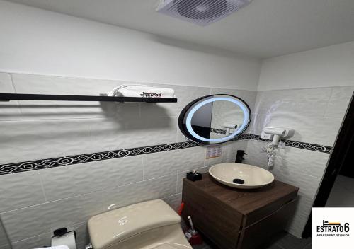 a bathroom with a toilet and a mirror at Estrato6 Apart Studios in Villanueva