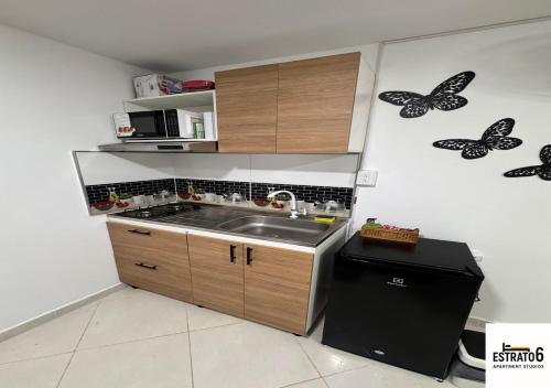 a kitchen with a sink and butterflies on the wall at Estrato6 Apart Studios in Villanueva