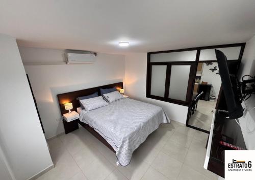 a bedroom with a bed and a television in it at Estrato6 Apart Studios in Villanueva