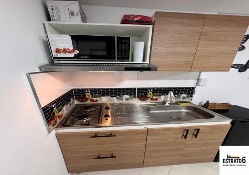 a small kitchen with a sink and a microwave at Estrato6 Apart Studios in Villanueva