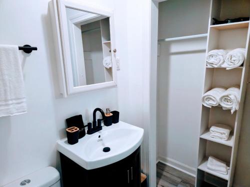 a white bathroom with a sink and a mirror at 2 Bedroom Kitchen and Living Area in Fayetteville