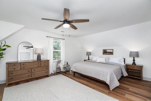 a white bedroom with a bed and a ceiling fan at Pickleball - 2 Master Suites - Fire Pit - Game Rm in Nellysford