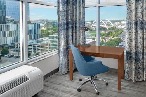 a desk and a chair in a room with windows at Hilton Garden Inn Nashville Downtown Convention Center in Nashville