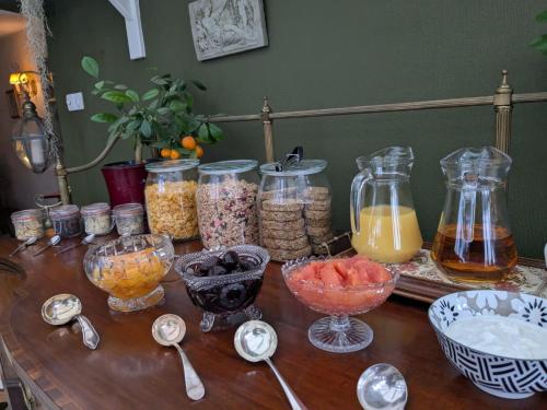 a wooden table topped with jars of food and spoons at Lydgate House Hotel in Postbridge
