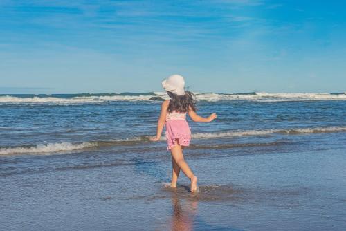 a little girl walking on the beach at Opaba Praia Hotel in Ilhéus