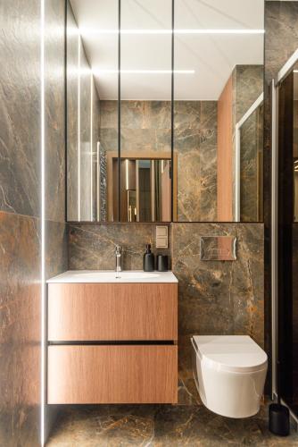 un bagno con lavandino, WC e specchio di Sea Waves Apartment a Palanga