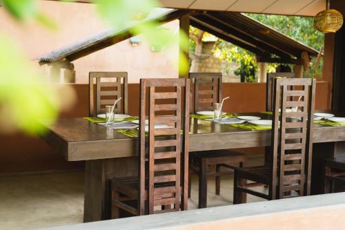 a wooden table with four chairs at a restaurant at Yala Green Eco Lodge in Kirinda
