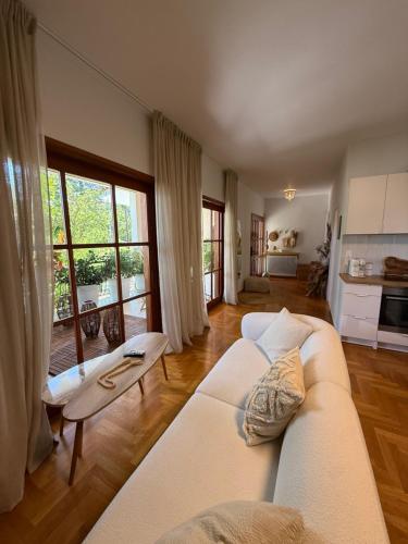 a living room with a white couch and a kitchen at Quiet luxury studio next to airport in Paianía