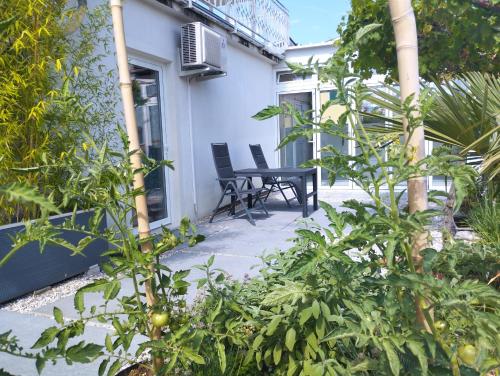 een patio met 2 stoelen en planten voor een huis bij Active Apartments Koper in Koper