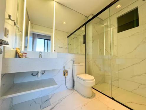 a bathroom with a toilet and a glass shower at Hotel Blue Sea in Itapema