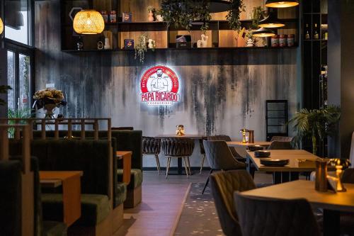 een restaurant met tafels en stoelen en een bord aan de muur bij SIGMA suites in Constanţa