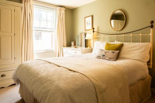 a bedroom with a large bed and a mirror at Windlass Cottage in Lymington