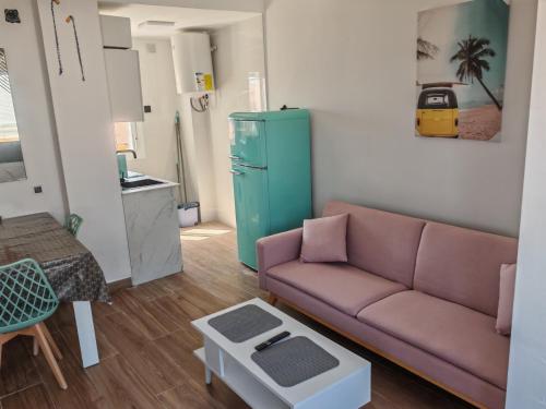 sala de estar con sofá y nevera verde en Apartamento Torrenueva en playa 4 planta, en Torrenueva