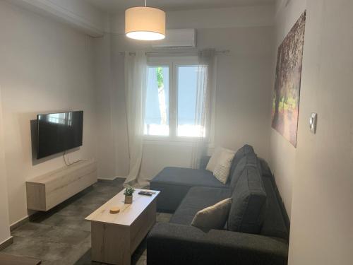 a living room with a couch and a tv at Eva Apartment in Ermoupoli