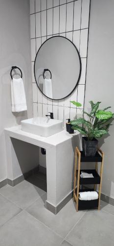 a bathroom with a white sink and a mirror at 72 on Circle in Bloemfontein