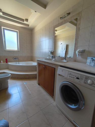 a bathroom with a washing machine and a tub at Villa Agapi in Pastida
