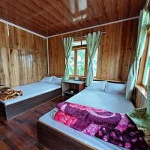 a bedroom with two beds in a wooden room at The Wooden Homestay By StayApart in Rishop