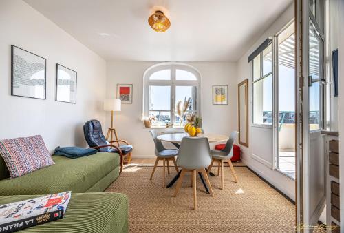 un salon avec une table et des chaises dans l'établissement joli toit terrasse Le Celtic, à Dinard