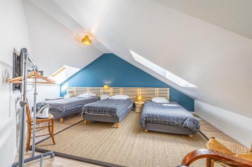 a attic room with three beds and a staircase at joli toit terrasse Le Celtic in Dinard