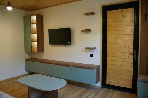 a room with a tv on the wall and a door at Netara in Khizabavra