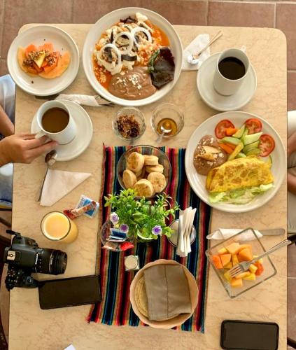 a table with plates of food and cups of coffee at Hotel y Restaurante Villas Del Sol Jalpan de Serra in Jalpan