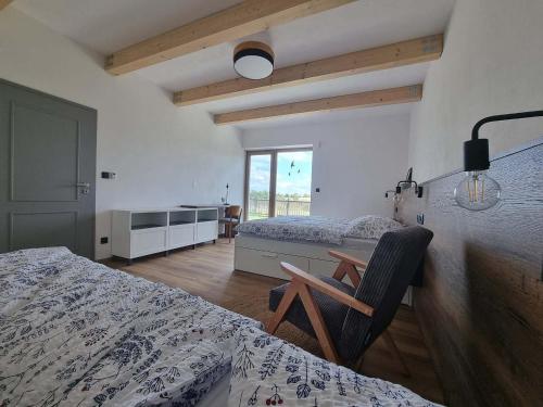 a bedroom with two beds and a table and a chair at Chalupa U Jasanu in Vílanec