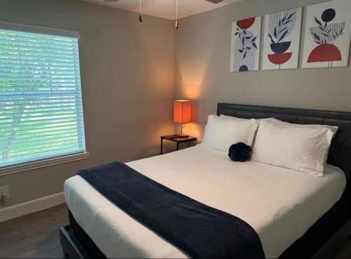 a bedroom with a bed and a lamp and a window at Apartment located in the Texas Medical Center near NRG, Discovery Green, Houston Zoo, Museum District in Houston