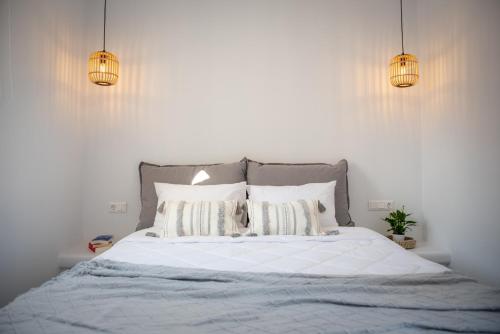 a bedroom with a bed with white sheets and pillows at Anthea Suites in Engares